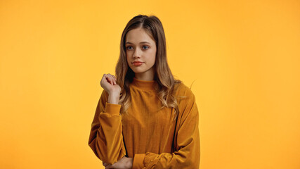 teenager in sweater looking away isolated on yellow