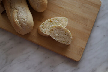 A wooden cutting board on a table with sliced bread. selectiv focus.
