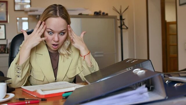 A lot of Paperwork and sad woman. Bored sad worker tired unmotivated and disinterested in dull work with laptop paperwork. Office clerk working, adding folders more work.