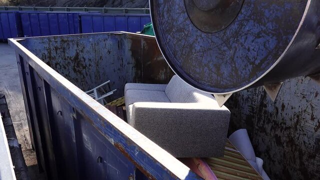 Stockholm, Sweden An industrial compacter crushes furniture in a container at a municipal dump. 