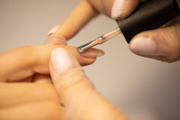 Nail polish woman to a beautician.Treatment hand and nail care the woman to a beautician for a manicure. Selective focus.