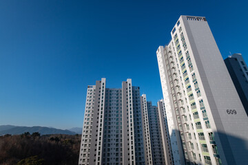 Fototapeta na wymiar Low angle view of an apartment tower in front of a blue sky in South Korea