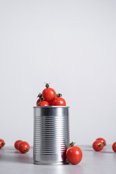 Tomates cherry en una lata de conservas sobre fondo gris