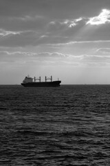 Bulk Carrier ship and sunlight beams. Transportation background photo. Shipment background.