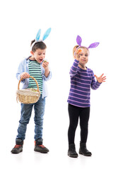 Happy excited little kids with bunny ears holding and shouting playing with Easter painted eggs. Full body isolated on white background. 