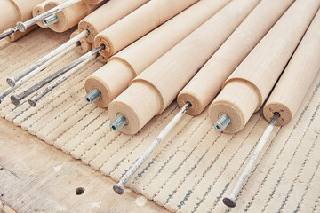 Lathe wooden legs of solid birch with built-in screw pin and nails folded on workbench closeup