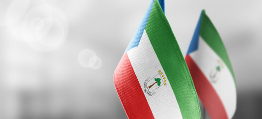 Small national flags of the Equatorial Guinea on a light blurry background