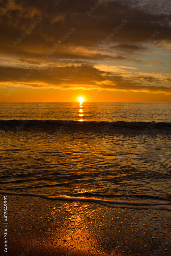 Wall mural A beautiful sunrise from the shore of the beach