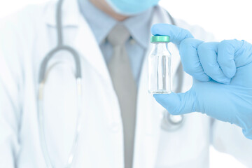 Close up vaccines fight against virus, doctor or scientist in laboratory holding a syringe with liquid vaccines.