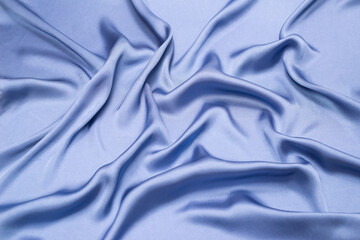 Blue silk or satin luxury fabric texture. Top view.