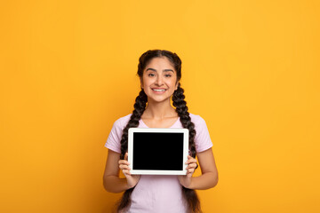 Smiling Indian woman showing blank tablet screen