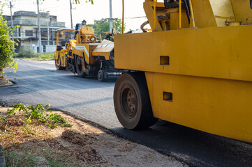 Heavy vibration yellow steamroller or soil compactor working on hot-mix asphalt pavement road
