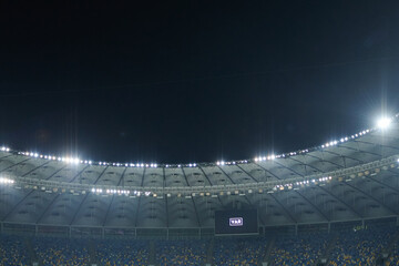 Stadium lit floodlighting into the darkness of the evening. Bokeh effect.