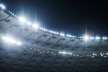 Stadium lit floodlighting into the darkness of the evening. Bokeh effect. - 417653588