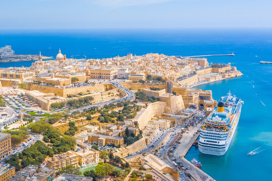 Aerial view of Lady of Mount Carmel church, St.Paul's Cathedral and a great bay with a cruise liner ship in Valletta city, Malta.