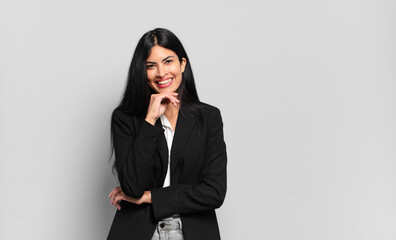 young hispanic businesswoman smiling, enjoying life, feeling happy, friendly, satisfied and...