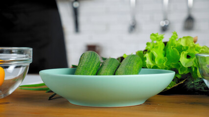 Close up fresh cucumber in plate with copy space, prepares ingredients vegetables for salad dish food at home kitchen