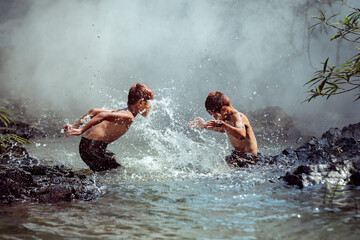 Two boys washing in a river, Thailand