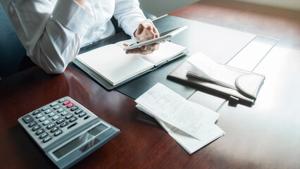 Woman with bills and calculator. Woman using calculator to calculate bills at the table in office....