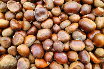 Close-up on a stack of organic chestnuts in a market stall.