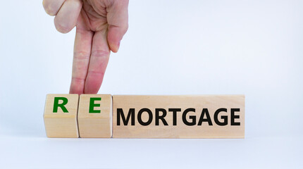 Mortgage or remortgage symbol. Businessman turns cubes and changes the word 'remortgage' to 'mortgage'. Beautiful white background, copy space. Business, Mortgage or remortgage concept.