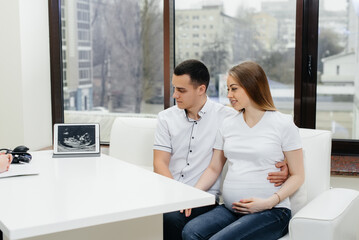 A young couple at a gynecologist's consultation after an ultrasound. Pregnancy, and health care