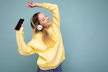 Beautiful happy smiling young woman wearing stylish casual outfit isolated on background wall...