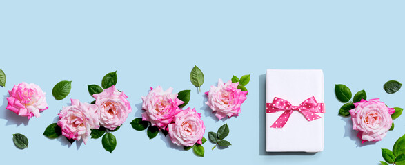 Gift box with pink roses overhead view - flat lay