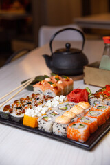 set rolls on a black square plate on a table in a cafe