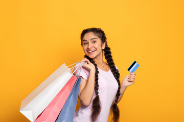 Indian lady holding plastic credit card and shopping bags