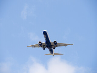 British Airways aeroplane coming into land seen from underneath against a blue sky