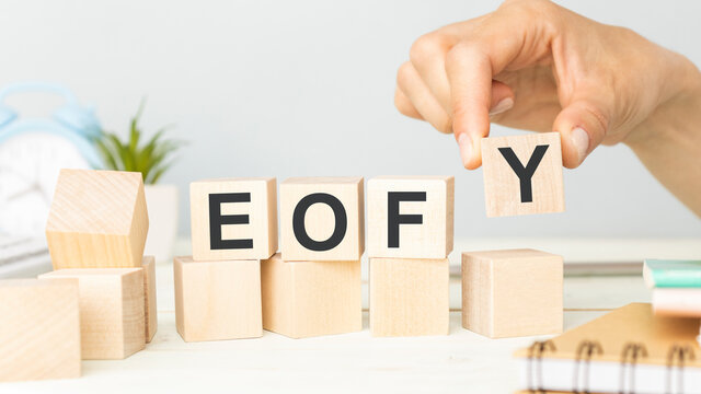 EOFY, End of Financial Year text. wood cubes and white background