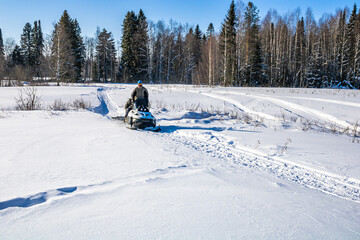 Family winter walks on a snowmobile in nature.