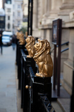 golden lion figures on a black ironing railing 