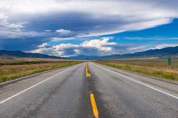 Scenic view of an empty road with mountains on the background, in the State of Colorado, USA; Concept for travel and road trip in the USA