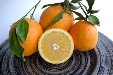 ripe and juicy orange. fresh orange cut in half on a background of oranges with leaves
