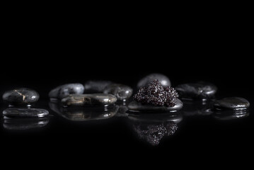 Caviar de esturión en piedra piedra negra con reflejo sobre fondo negro