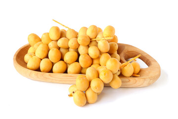 Yellow dates on wooden tray isolated on white