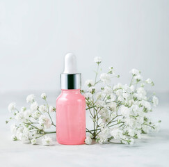 Obraz na płótnie Canvas Bottle of cosmetic liquid on white background. Cosmetics packaging design concept or mock-up surrounded by delicate gypsophila flowers