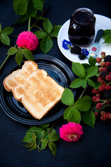Toasted on Black Plate With a Jar of Homemade Organic Blackberry Jam on Black Background
