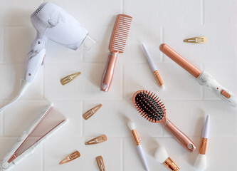 Beautiful modern rose gold hair styling products on white background