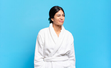 young hispanic woman looking happy and friendly, smiling and winking an eye at you with a positive...