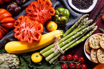 Composition with raw vegetables asparagus and ox heart tomatoes