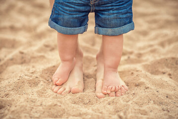 Fototapeta na wymiar dad and daughter feet on the sand