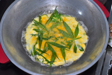Creamy Omelet with organic Cannabis on pot. Soft focus.