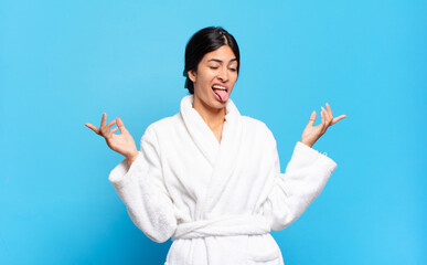 young hispanic woman shrugging with a dumb, crazy, confused, puzzled expression, feeling annoyed...