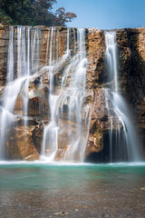 Smooth Long Exposure of Waterfall. Creamy Beautiful waterfall falling off a cliff in the mountas.