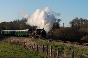 Fototapeta na wymiar a double headed steam train leaves Norden on the Swanage Heritage Railway 