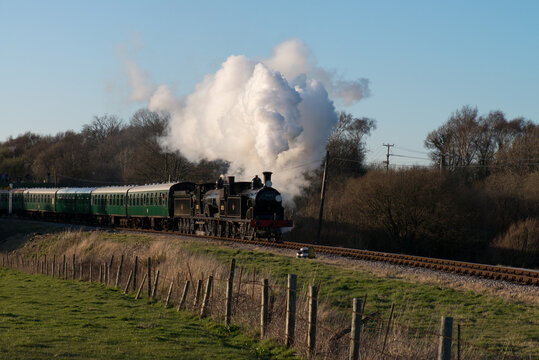 a double headed steam train leaves Norden on the Swanage Heritage Railway 
