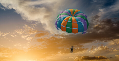 Couple enjoy parasailing flight during sunset